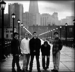 Oasis's original line-up - Guigsy, Bonehead, Noel Gallagher, Liam Gallagher, and Tony McCarroll